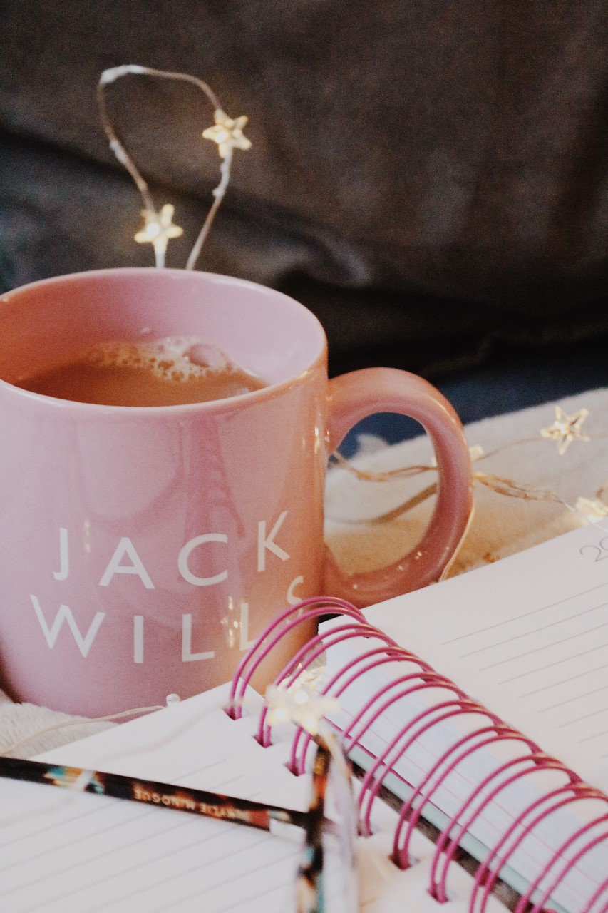 Weekly Blogging Tasks: A cup of tea in a pink Jack Wills mug, with an open notebook in front of it